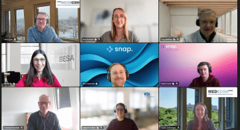 Online-Meeting mit 9 Kacheln. In jeder Kachel ist das Gesicht einer anderen Person zu sehen